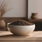 Un pot en céramique brut, posé sur une surface en bois, avec un fond naturel rappelant la terre et la simplicité de la matière.