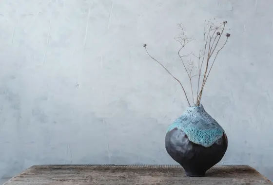 Vase en céramique artisanale émaill posé sur une table en bois, dans une ambiance naturelle et minimaliste.