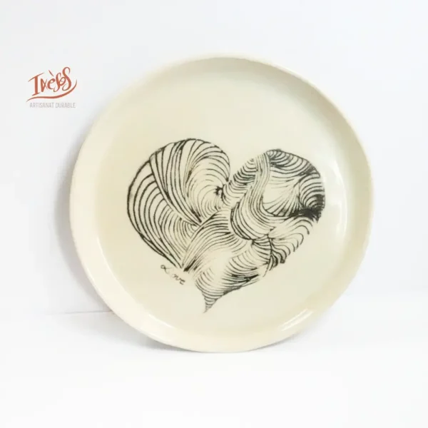 Assiette en céramique artisanale Ixèsos U Ligame avec cœur dessiné en lignes imbriquées, façonnée à la main.